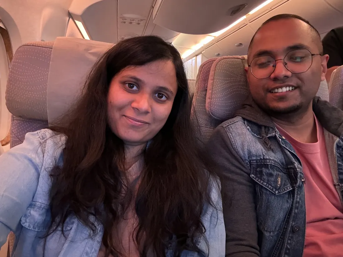Arsha and Binu smiling in their plane seats before take-off