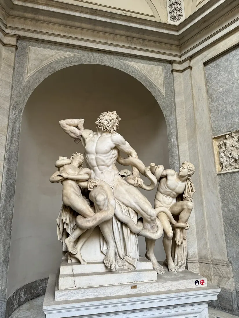 The Laocoön marble group: a father and two sons wrestling with serpents, in a stone niche