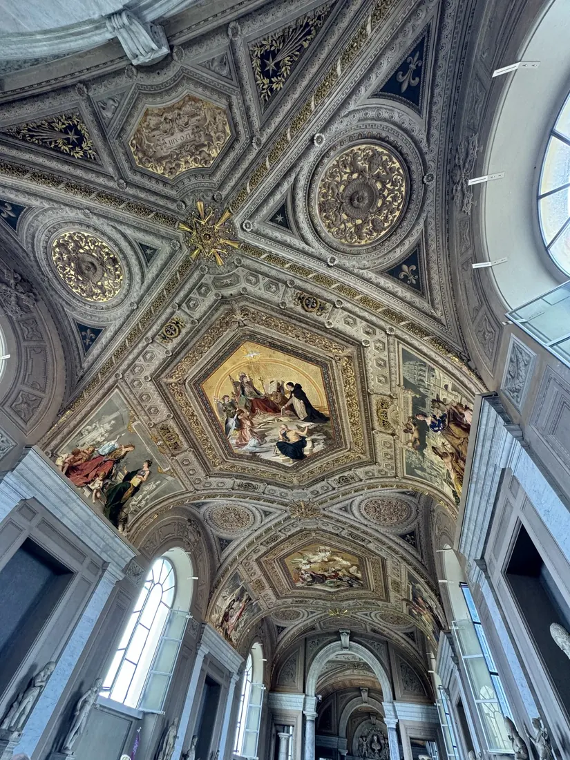 A richly painted and gilded vaulted ceiling over a long gallery