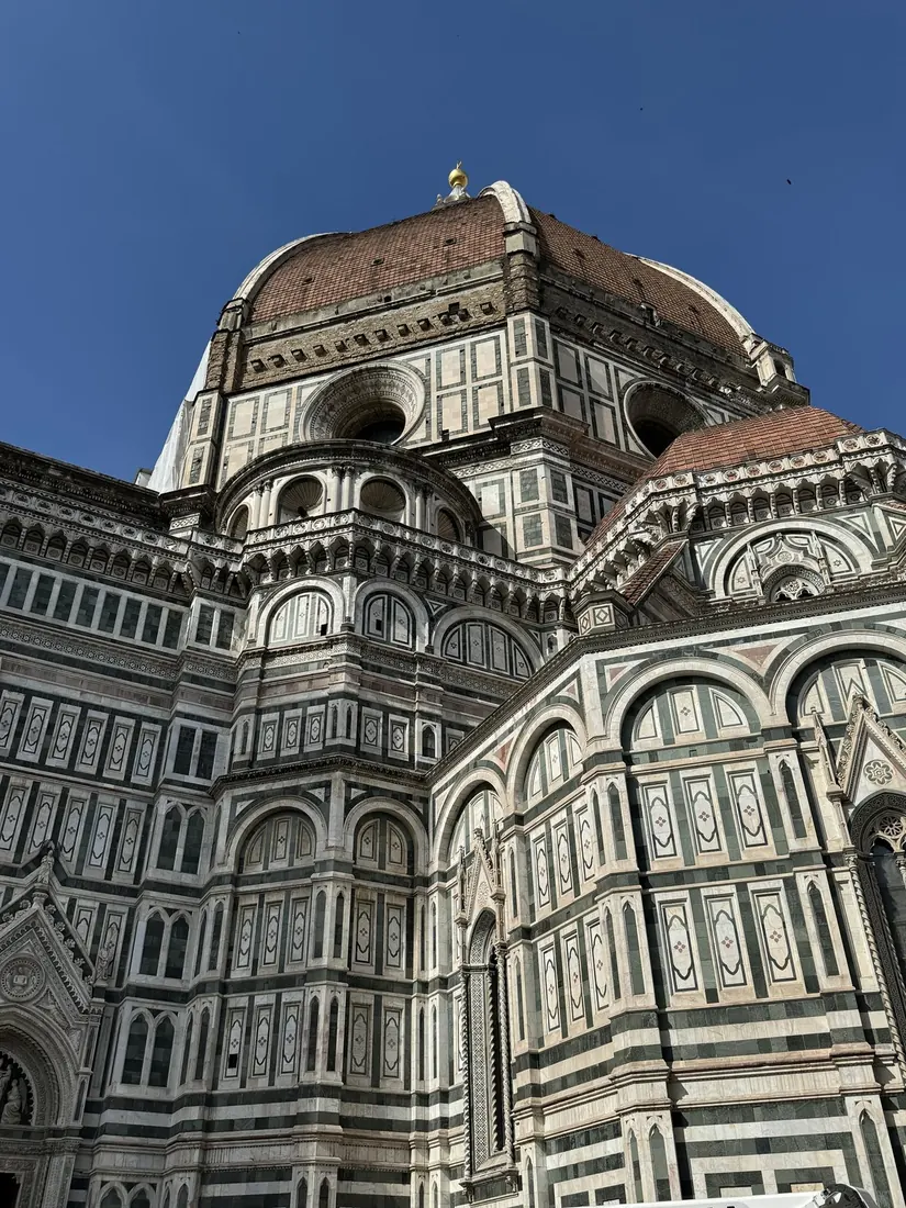 Brunelleschi's red brick dome rising over the white, green and pink marble of Florence Cathedral