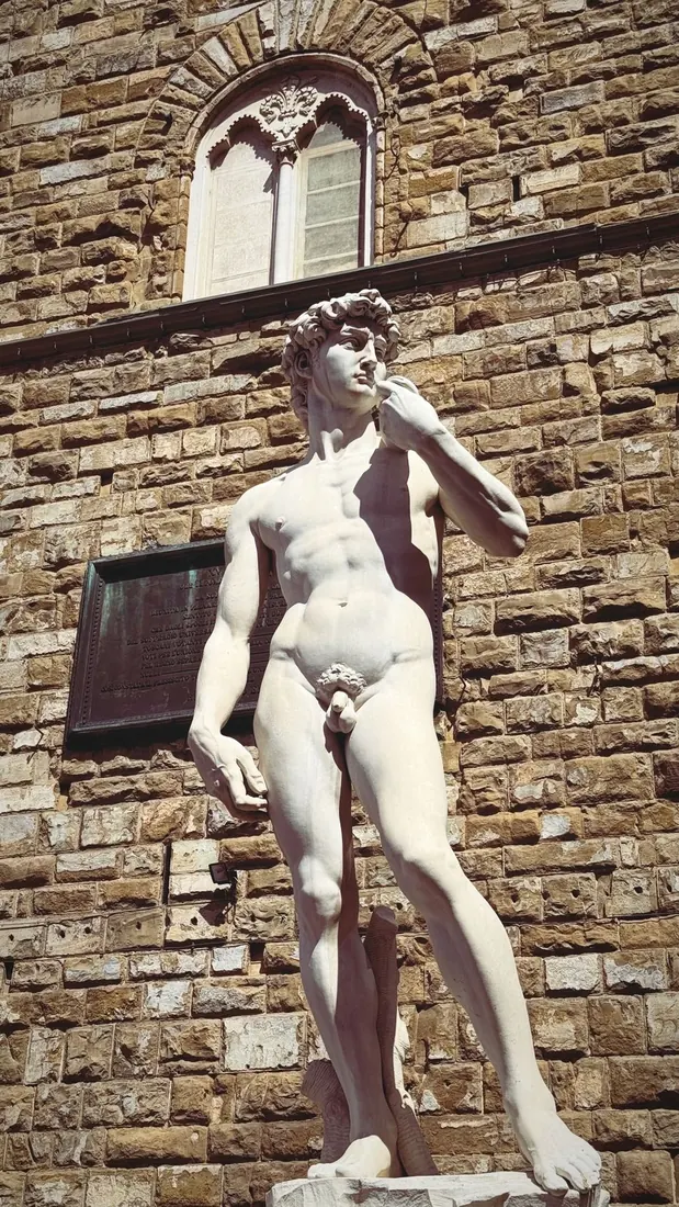 The marble replica of Michelangelo's David against the rough stone of the Palazzo Vecchio