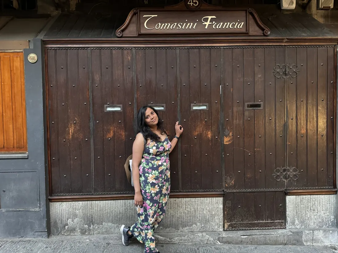 Arsha leaning on the big wooden shutters of a closed jeweler's shop on the Ponte Vecchio