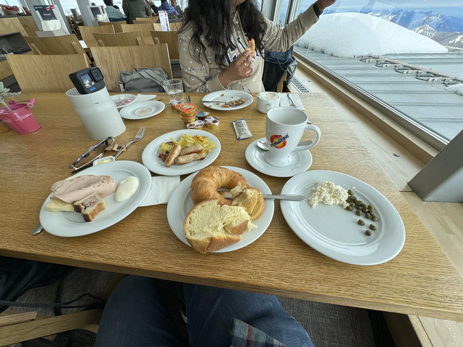 Brunch plates with bread, cheese and coffee on a table by the window at Piz Gloria