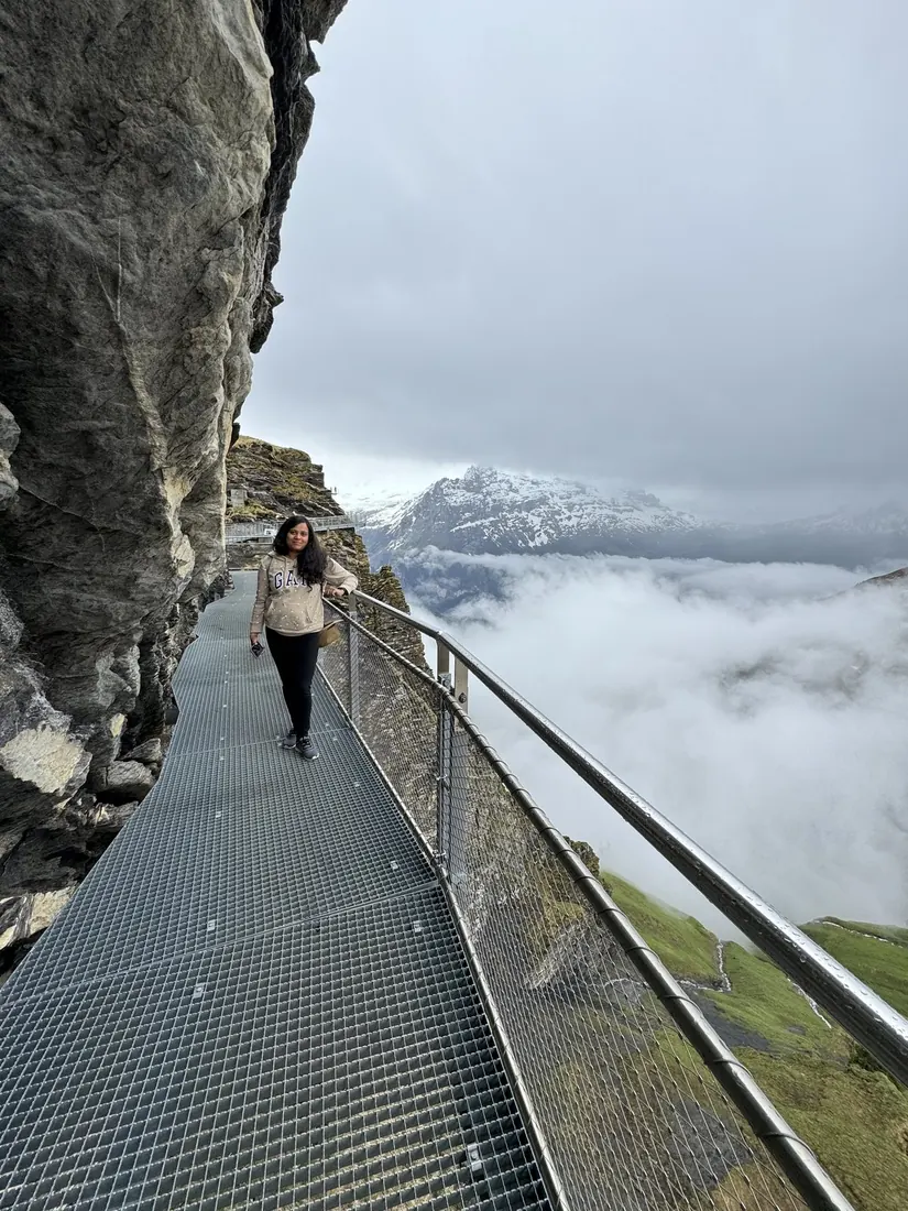 Arsha on the metal First Cliff Walk hugging the rock face, a sea of cloud below