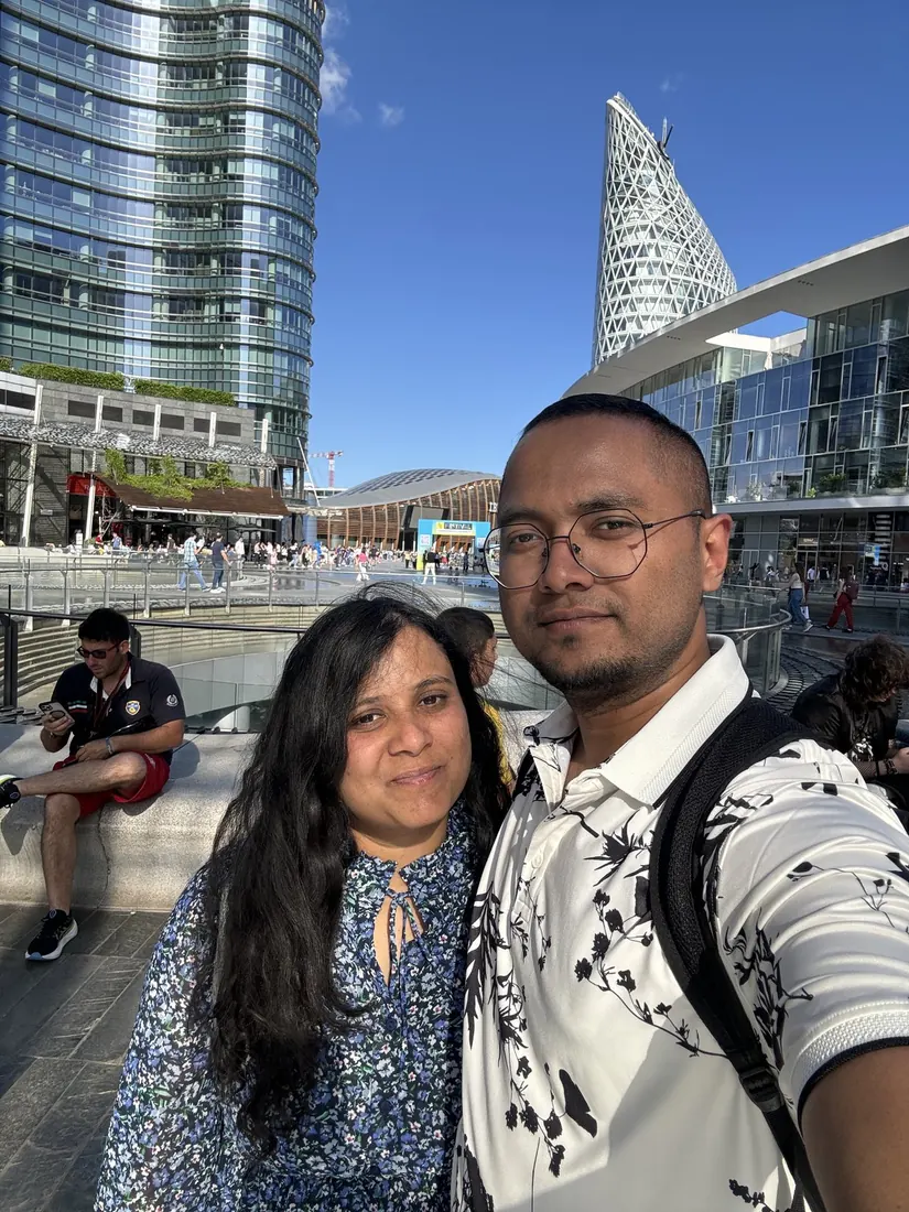 Selfie of Arsha and Binu in Piazza Gae Aulenti, glass towers behind