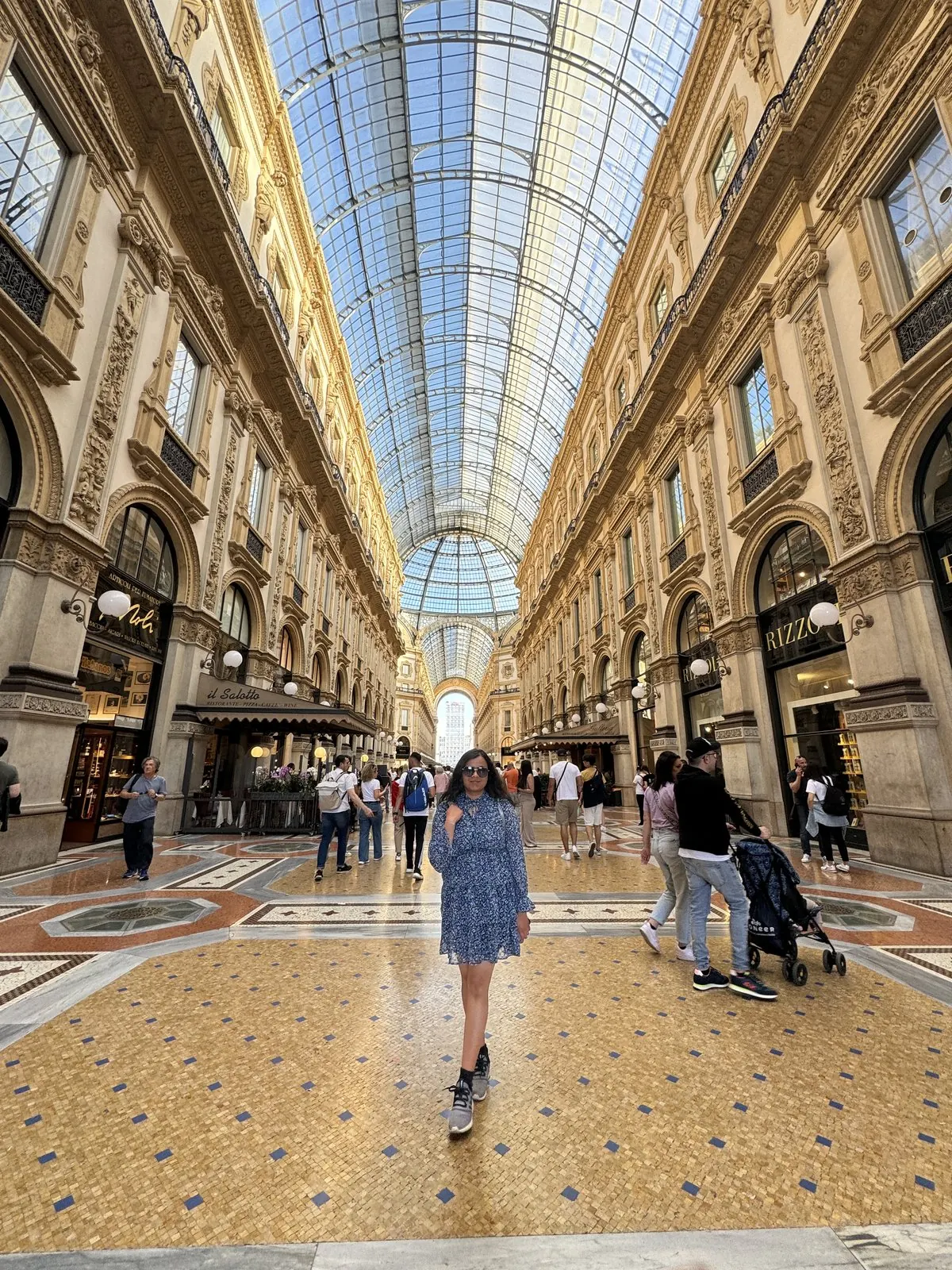 Arsha walking under the glass roof of the Galleria Vittorio Emanuele II, mosaic floor beneath